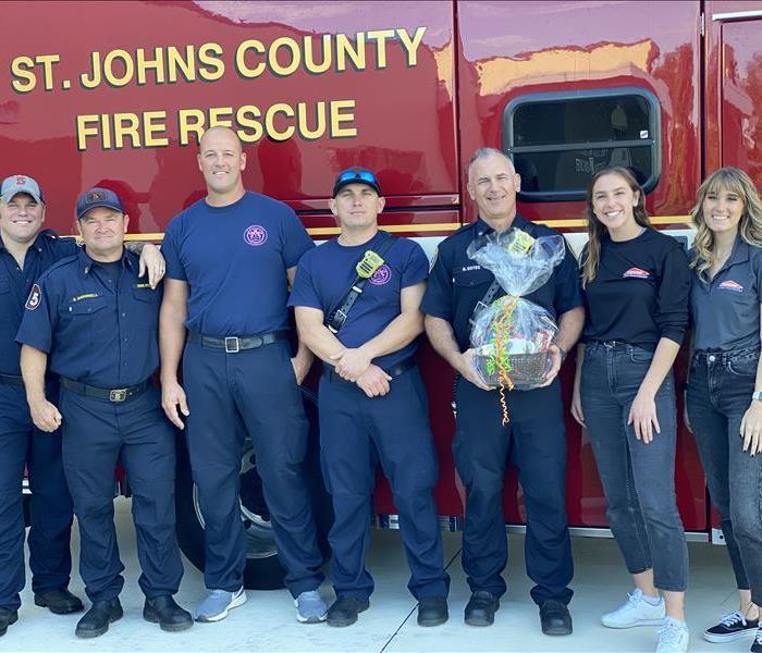 SEVPRO female employees standing with local St. Johns County Fire Rescue Fire Fighters 