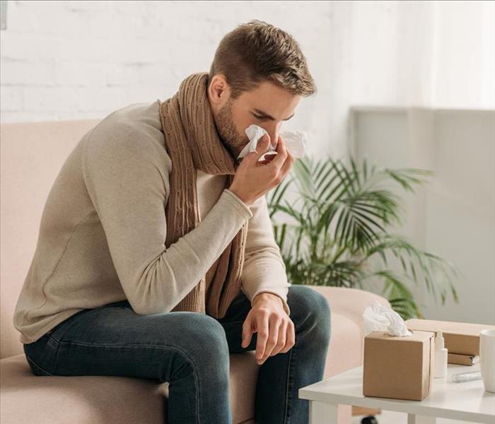 Man in scarf blowing his nose in Florida home